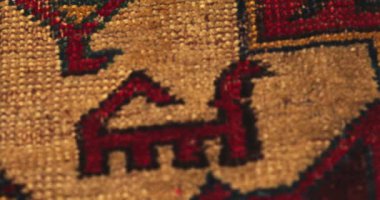 Semerkand ustalarının antik teknolojiyi kullanarak yaptığı el yapımı eski püskü bir halıyı yakından çek. Ulusal şablon ve süslemelerle kaplıdır..