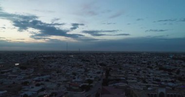 Eski Buhara, Özbekistan 'daki evlerle çevrili antik bir Lyab-i Hauz kompleksinin üzerinde bir İHA uçuyor. Bulutlu bir gece. Hava Görünümü.