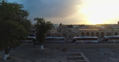 Buhara 'nın antik sandığı yakınlarındaki turist otobüslerinin üzerinden bir İHA uçuyor. Eski Buhara, Özbekistan. Hava Görünümü.