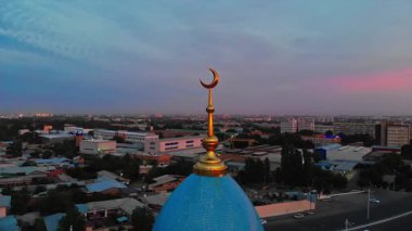 Bir İHA şehrin camisinin etrafında Sunrise 'ın arka planına doğru uçuyor. Bulutlu bir sabah. Hava Görünümü.
