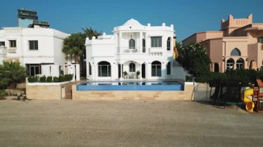 Bir İHA Dubai 'de yüzme havuzu olan lüks bir özel villanın önünde uçuyor. Yavaş Hareket.