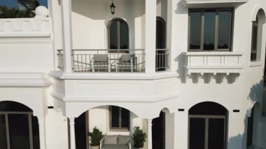 Bulutsuz bir günde Dubai 'de, deniz kenarında palmiye ağaçlarının arasında pahalı bir villanın dışında. Yavaş Hareket.