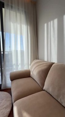 Dubai 'de pahalı bir özel villada oturma odası. Panoramik pencerelerden güneş ışığı alıyor. Yavaş Hareket.