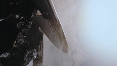 Pahalı, özel bir bıçak. Taşlar arasında duman bulutları arasında kaliteli bir tasarımı var. Yavaşça kameranın önünde dönüyordu. Yakın plan.