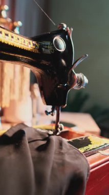 Dubai, BAE - 26 12 2023: atölyede dikiş makinesi üzerinde çalışan usta atölyenin eli. Kapat, Yavaş Hareket.