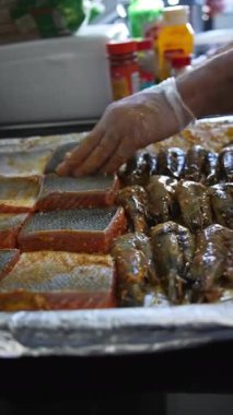 Şef kızartmadan önce çiğ balık parçalarını tepsiye koyar. Kapat, Yavaş Hareket