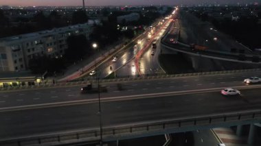 Yoldan geçen arabalarla bir gece köprüsünün üzerinde insansız hava aracı. Hava Görünümü