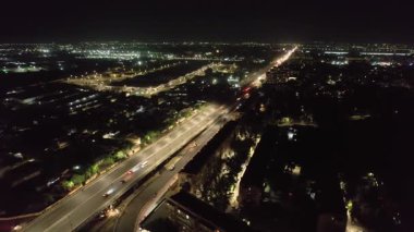 Yoldan geçen arabalarla bir gece köprüsünün üzerinde insansız hava aracı. Hava Görünümü