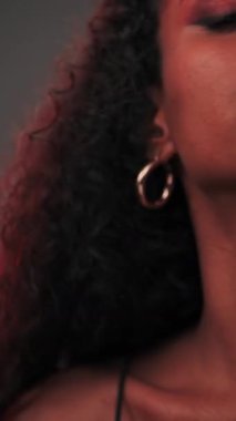 Afro saçlı ve parlak makyajlı esmer bir kadının portresi. Yavaş Hareket