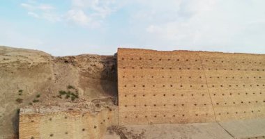 Özbekistan 'ın Buhara kentindeki eski evlerle çevrili antik Ark kalesinin tuğla duvarları. Bulutlu bir sabah. Drone, Hava Görüntüsü.