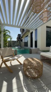 Güneşli bir günde Dubai 'de özel bir villanın arka bahçesinde küçük bir yüzme havuzu ve kanepesi var. Dışarıda ağır çekim.