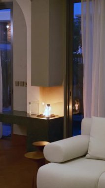 Dubai 'de özel pahalı bir villada şömineli oturma odası. Panoramik pencerelerden güneş ışığı alıyor. Yavaş Hareket.