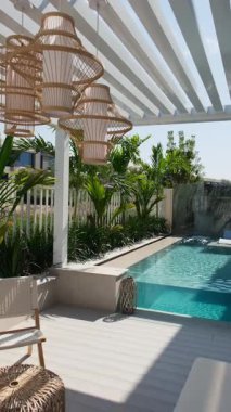 Güneşli bir günde Dubai 'de özel bir villanın arka bahçesinde küçük bir yüzme havuzu ve kanepesi var. Dışarıda ağır çekim.