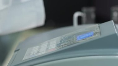 Beyaz önlüklü ve koruyucu eldivenli bir adam bir kimya laboratuvarında bilimsel bir aletle çalışıyor. Yavaş Hareket