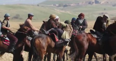 Taşkent, Özbekistan - 210 2023: Bir grup atlı, tepelerdeki sarı sonbahar çimenleri arasında dörtnala koşuyor. Orta Asya, Yavaş Hareket, Yakın Çekim.