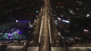 Şehrin her gece aydınlanan sokaklarında bir dron. Sokaklar boyunca arabalar ve kamyonlar sürüyor. Bulutsuz bir yaz gecesi. Hava Görünümü.