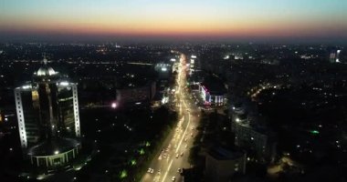 Gece aydınlık bir şehrin üzerinde bir dron. Bulutsuz bir yaz gecesi. Hava Görünümü.