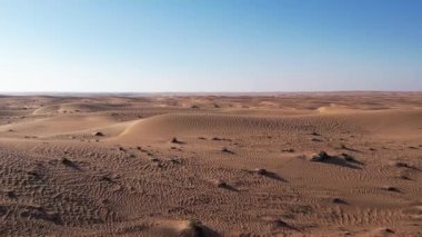 Dubai 'deki çölün kum tepelerinde bir dron. Güneşli bir yaz günü, ıssız bir yol. Hava Görünümü