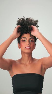 Siyah kıvırcık saçlı ve parlak makyajlı esmer bir kadının portresi. Gülümsüyor ve gülüyor. Kapat, Yavaş Hareket