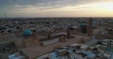 Özbekistan 'ın Buhara kentindeki eski evler arasında Poi-Kalon mimari kompleksinin üzerinde bir dron uçuyor. Erkenden bulutlu bir sabah. Hava Görünümü.