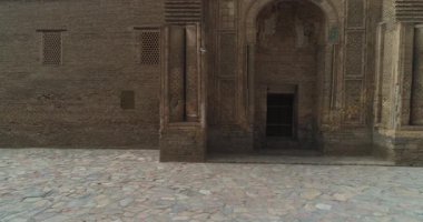 İnsansız hava aracı Özbekistan 'ın eski Buhara kentindeki Magok-i-Attari cami kompleksinin antik kapılarına yakın uçuyor. Bulutlu bir gün. Hava Görünümü.