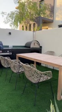 Güneşli bir günde Dubai 'de özel bir villanın arka bahçesinde küçük bir yüzme havuzu ve kanepesi var. Dışarıda ağır çekim.