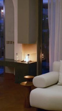 Dubai 'de özel pahalı bir villada şömineli oturma odası. Panoramik pencerelerden güneş ışığı alıyor. Yavaş Hareket.