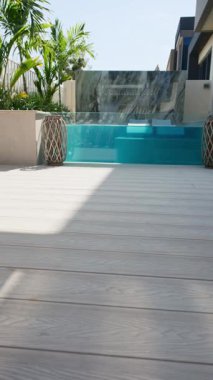 Güneşli bir günde Dubai 'de lüks bir villanın arka bahçesinde küçük özel bir yüzme havuzu. Dışarıda, Yavaş Hareket.