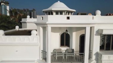 İHA mavi bulutsuz bir gökyüzünün arka planında yüzme havuzu olan özel bir Arap villasının etrafında uçuyor. Hava Görünümü