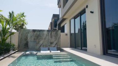 Güneşli bir günde Dubai 'de lüks bir villanın arka bahçesinde küçük özel bir yüzme havuzu. Dışarıda, Yavaş Hareket.