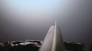 Taşlar arasında su damlalarında özel bir mutfak bıçağı. Işık ışınları içinde yavaşça döner. Yakın plan.