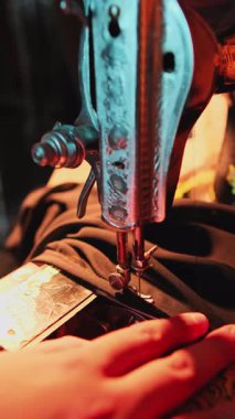 Bir atölyede dikiş makinesine elbise diken bir ustanın elleri. Kapat, Yavaş Hareket