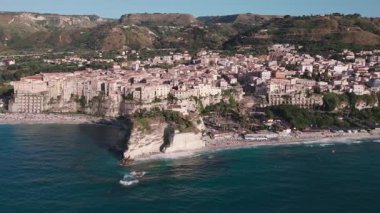 Uçurumlardaki antik bir sahil şehrinin üzerinde bir dron. Sakin deniz, bulutsuz bir gün. Tropea, İtalya. Hava Görünümü.