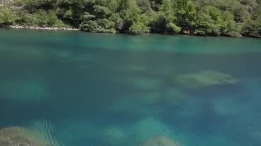 Bir dron dağ gölünün sularında bir vadide uçuyor. Bulutlu bir yaz günü. Hava Görünümü