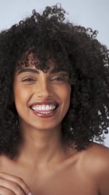 Kasvetli saçı ve parlak makyajı olan genç bir mankenin dikey portresi. Rujlu boya küpleri. Yavaş Çekim, Yakın Çekim. Stüdyo çekimi.