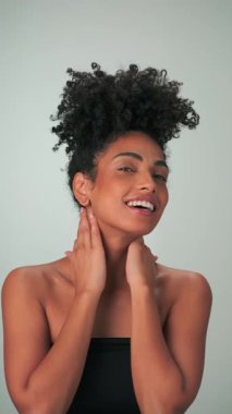 Siyah kıvırcık saçlı ve parlak makyajlı esmer bir kadının portresi. Gülümsüyor ve gülüyor. Kapat, Yavaş Hareket