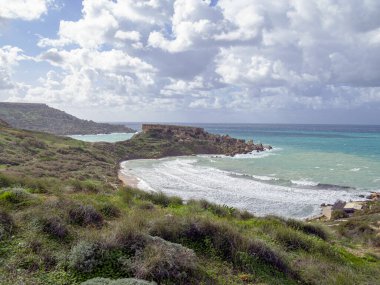 Golden Bay plajı, Malta adaları. Rüzgârlı bulutlu havada manzara