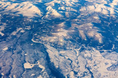 Aerial view of frozen mountains and rivers in the North Pole