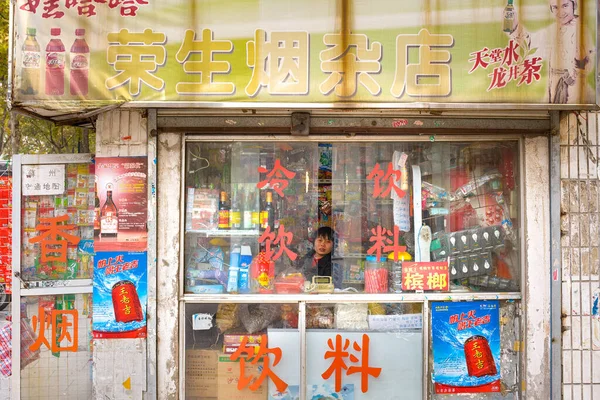 stock image Suzhou, Jiangsu Province, China, A woman inside a street food kiosk with and assortment of merchandise.