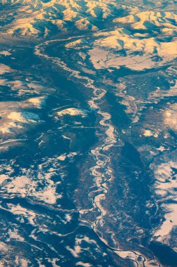 Aerial view of frozen mountains and rivers in the North Pole