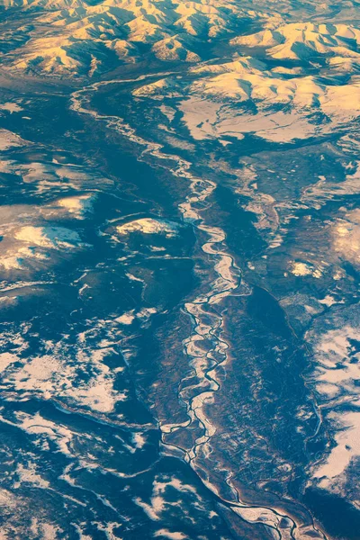 Aerial view of frozen mountains and rivers in the North Pole