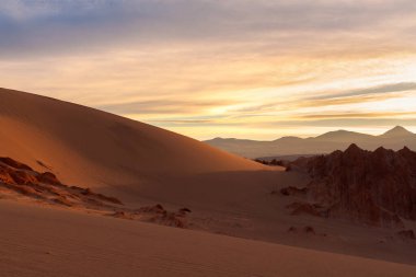 Şili 'nin Atakama Çölü' ndeki San Pedro de Atacama yakınlarındaki Valle de la Muerte 'de tuz oluşumlarını ve kum tepelerini aydınlatan gün doğumu.