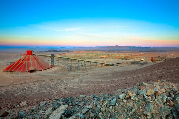 Conveyor belt and stockpile under a dome at an open-pit copper mine in Chile.