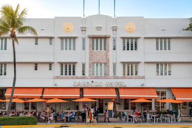 Miami Beach, Florida, ABD: Ocean Drive boyunca turuncu şemsiyelerle dolu canlı bir restoran, Güney Sahili 'nin büyüleyici deco mimarisi ile çevrili..