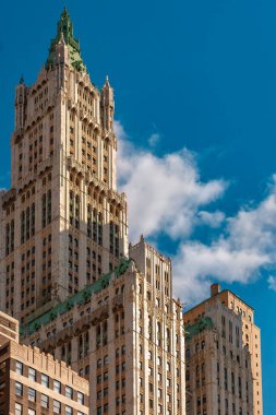 New York, New York, New York, Amerika Birleşik Devletleri - Woolworth Binası, Manhattan 'da tüylü bulutları olan açık mavi gökyüzüne karşı eşsiz mimari detaylarını ve tarihsel önemini gözler önüne seriyor..