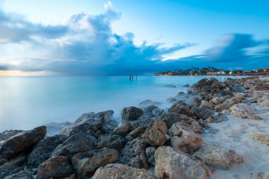 Aruba 'daki Divi Sahili' nde alacakaranlıkta yumuşak kumlar ve yumuşak dalgalar bulunur. Ziyaretçiler, tropikal atmosferde güneşlenirken ve doğal güzellikleri sersemletirken huzurlu anların tadını çıkarabilirler..