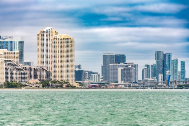 Miami ve Brickell şehir merkezinin ufuk çizgisi, Port Boulevard ve Skyview Miami Wheel ile dramatik bir gökyüzü.