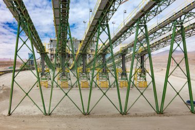 Şili bakır madenciliği: Mineral cevheri, üretimdeki önemli bir adım olan çoklu taşıma bantları aracılığıyla ezme tesisine giriyor.