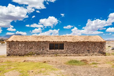 Şili Atacama Çölü 'nün ortasında, saman çatılı taştan bir kulübe dramatik bir çöl gökyüzünün altında barınak sağlar..