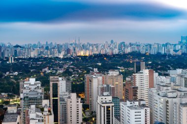 Sao Paulo 'nun etkileyici silueti, şehrin yoğun nüfuslu şehir merkezi manzarası ve karanlık çöktüğünde çevresindeki mahalleler..